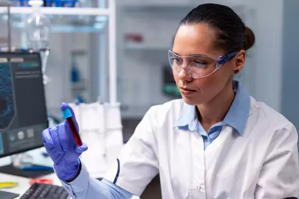 Female student examining a blood sample during Diploma in Medical Laboratory Technology practical training.